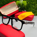 Black Cartier eyeglasses on a red case with a yellow cloth and green plant in the background