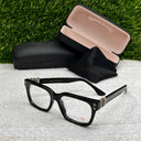 Black eyeglasses with a case on a textured surface with grass background