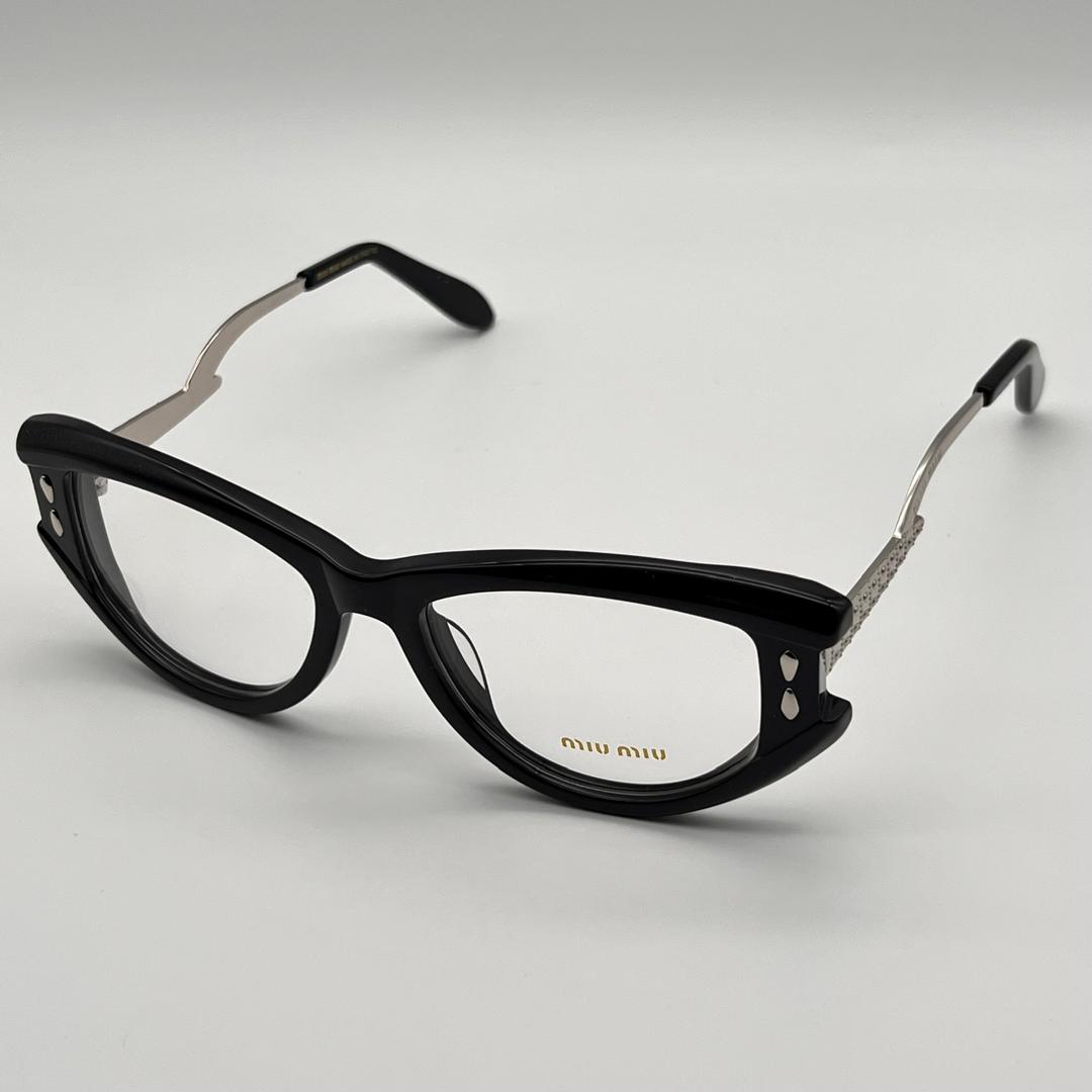 Black cat-eye glasses with silver accents on a light gray background