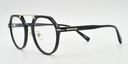 black frame with gold colour bridge. side view octagonal frame with round lenses. gold details on arm close to the hinge