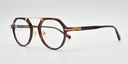 brown frame with gold colour bridge. side view octagonal frame with round lenses. gold details on arm close to the hinge