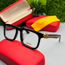 Black Cartier eyeglasses on a red Cartier case with green grass in the background