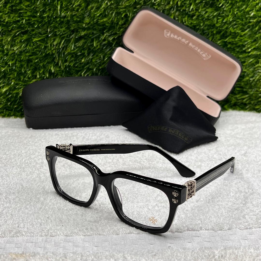 Black eyeglasses with a case on a textured surface with grass background