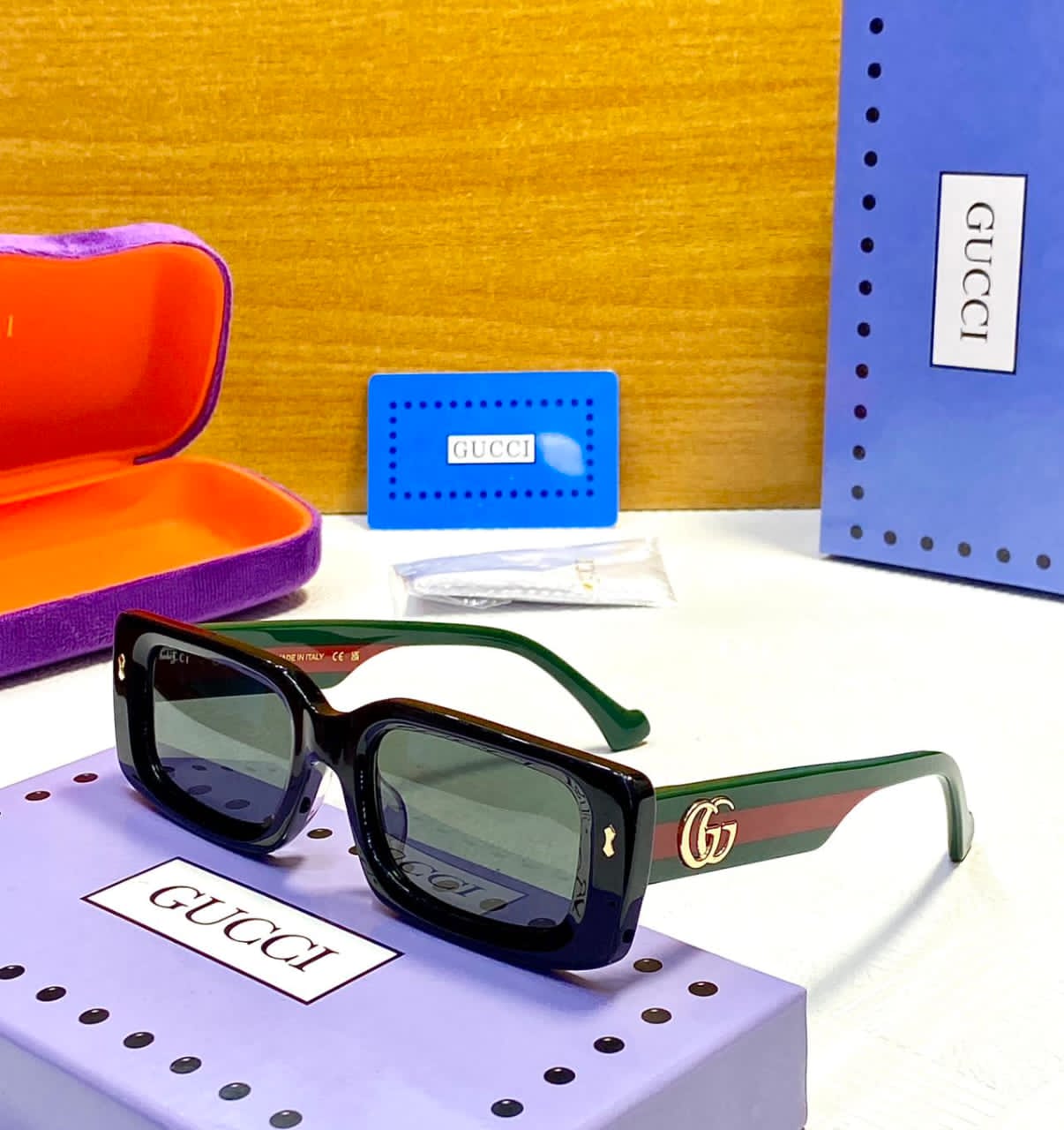 Gucci sunglasses with packaging on a yellow background