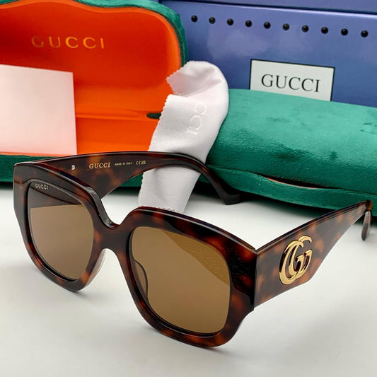 Tortoiseshell Gucci sunglasses with case and box in the background