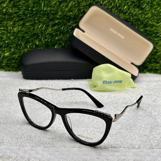 Black eyeglasses with case and cleaning cloth on a textured surface with grass background