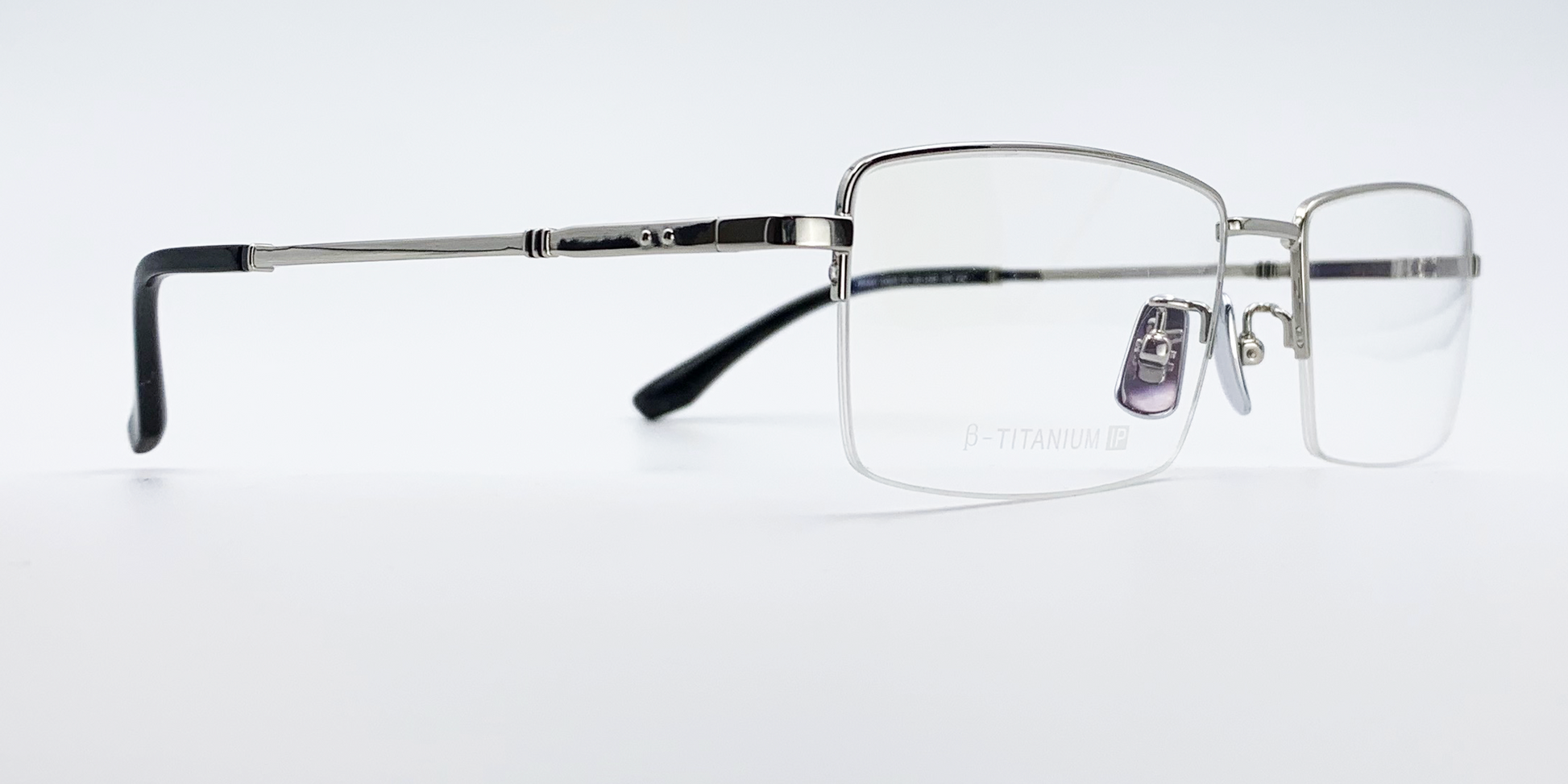 silver coloured rectangular titanium half frame. side view showing silver coloured bridge and arm