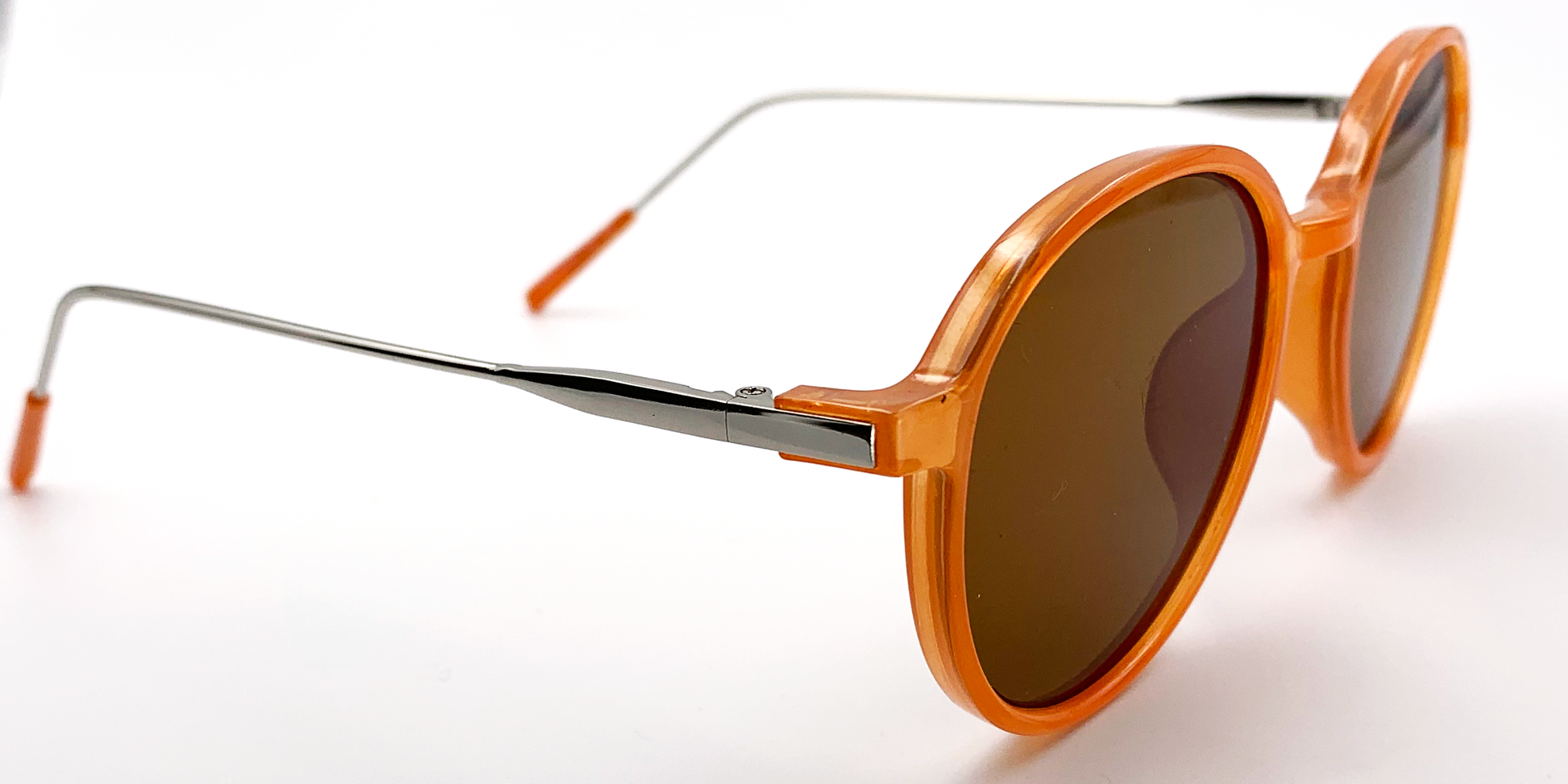 orange round glasses. Side view with tinted lenses showing silver coloured arms