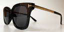 side view of dark brown rectangular rounded frame with tinted lenses. gold embellishments at the hinges and gold colour arms