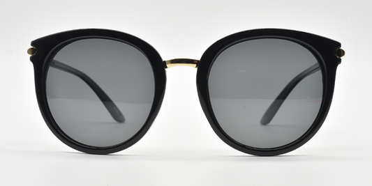 Front view. Round black frame showing tinted lenses and gold coloured bridge.