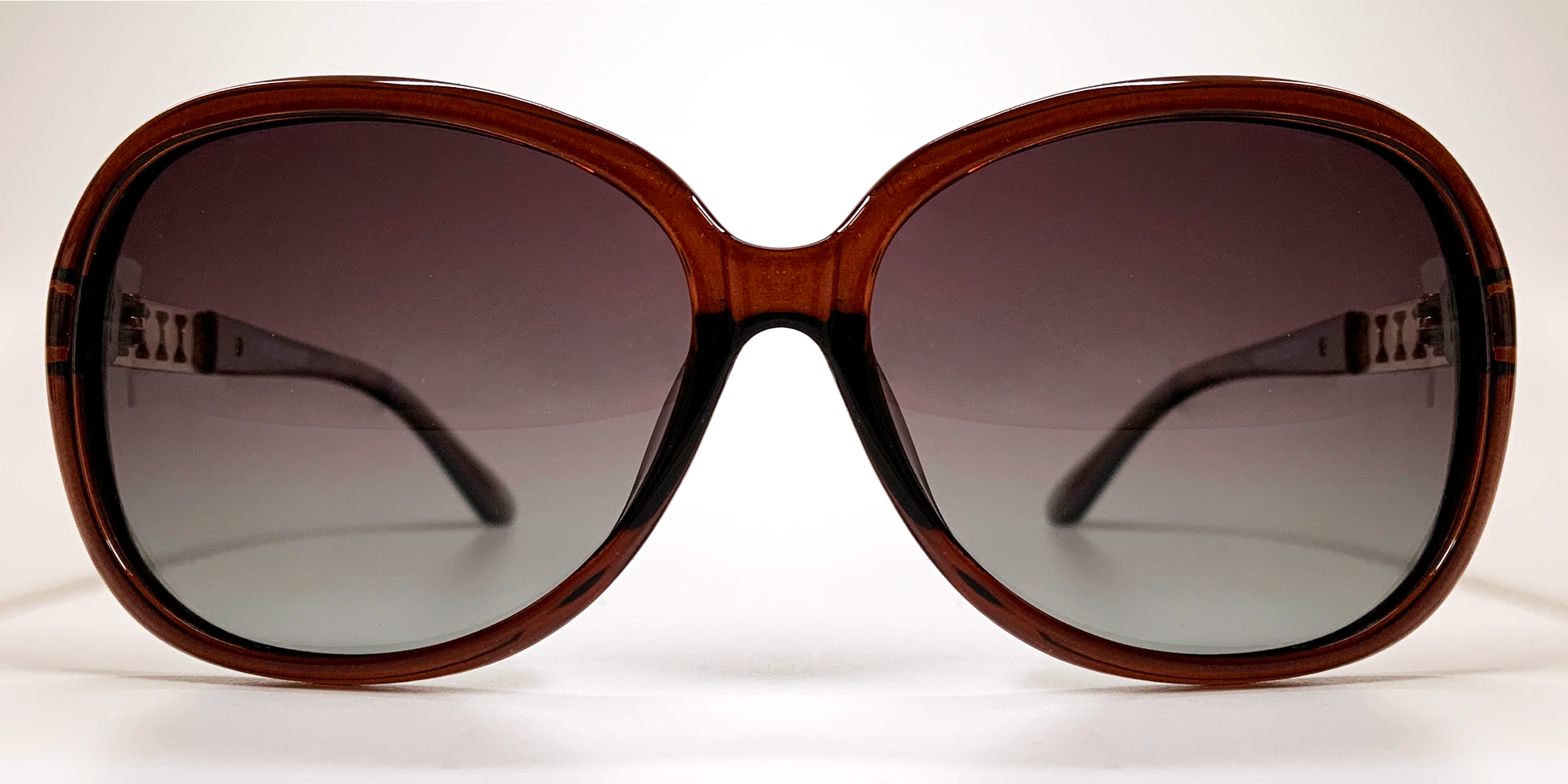 Front view, large rounded rectangular black frame with tinted lenses