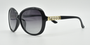 side view, large rounded rectangular black frame with tinted lenses. gold with 5 small gemstones detail on top part of the arm.