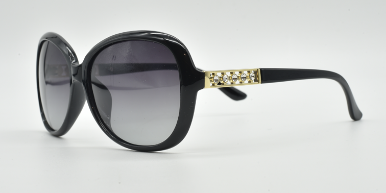 side view, large rounded rectangular black frame with tinted lenses. gold with 5 small gemstones detail on top part of the arm.