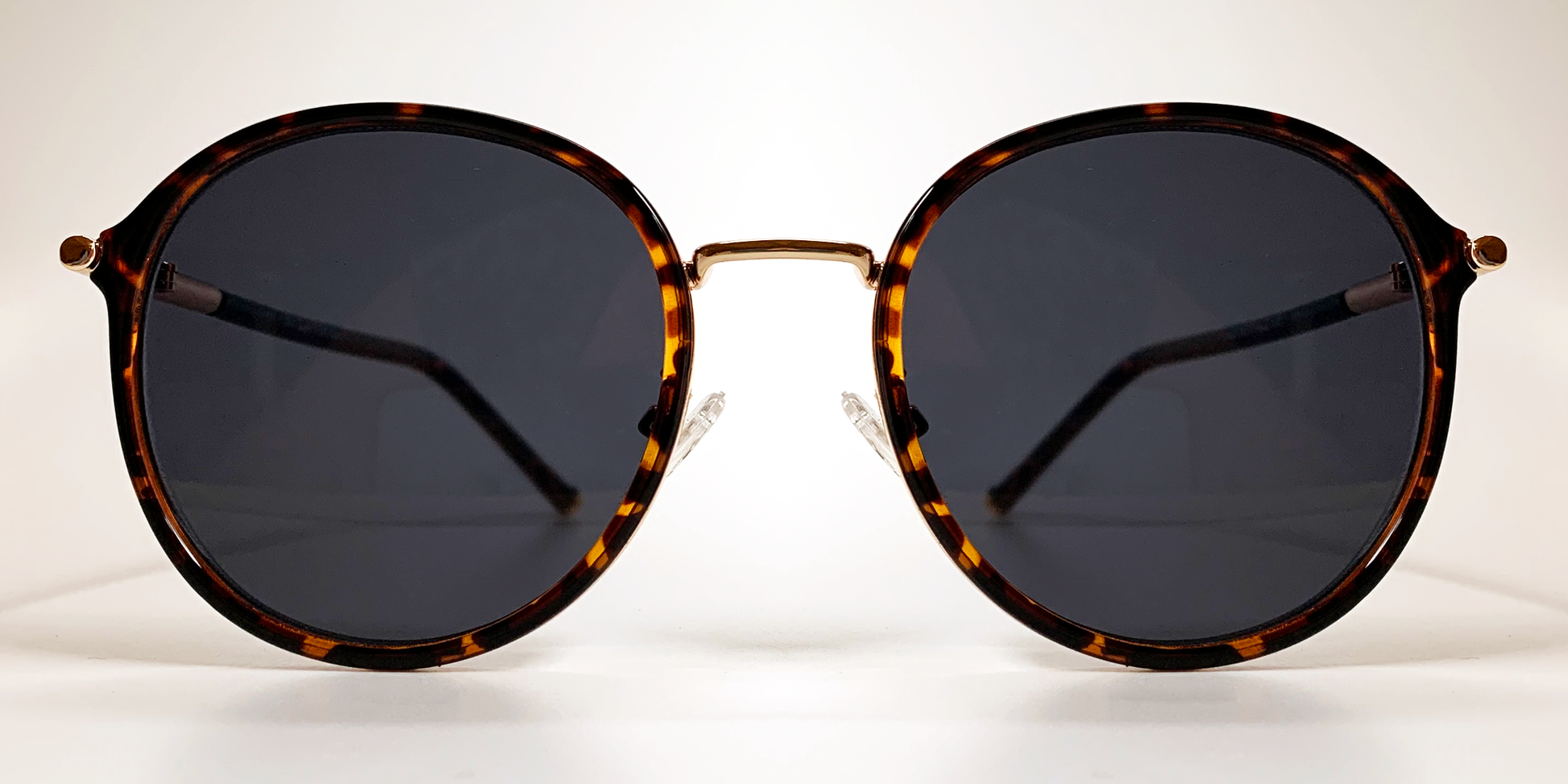 front view of round retro-style tortoiseshell  frame with gold coloured bridge and gold embellishments 