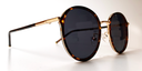 side view of round retro-style tortoiseshell frame with tinted lenses, gold coloured bridge and gold embellishments around the frame and top of the arms