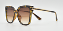 side view tortoiseshell rounded rectangular frame with small circular detail on front extending down the arms. Tinted lenses.