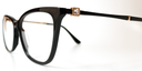 side view. showing square crystal feature, with gold coloured surround, close to the hinge area Black cat's-eye frame glasses. Gold inner, black outer coloured arms.