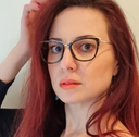 Female model with long red hair modelling tortoiseshell  cat's-eye frame showing gold coloured highlights to the top corners of the frame. 
