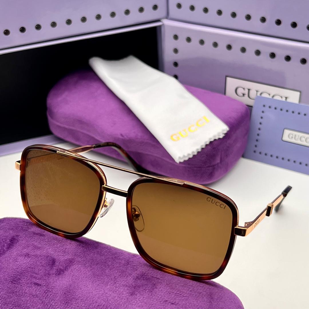Gucci sunglasses with a purple case and cloth on a white surface