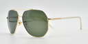 Aviator style glasses. Gold colour rims, bridge and arms. side view with green tinted lenses.