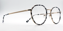 black and white round retro-style frame. Side view showing gold coloured bridge and arm