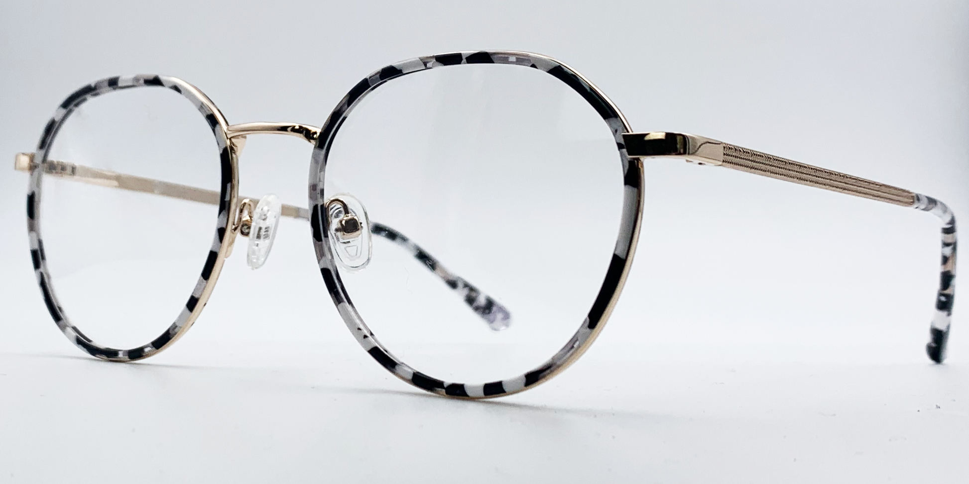 black and white round retro-style frame. Side view showing gold coloured bridge and arm